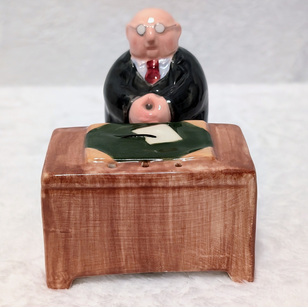 Vintage salt and pepper shakers. Executive behind his desk.